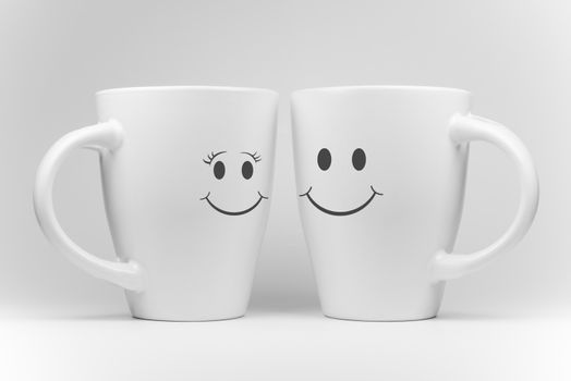Two white mugs in a mirrored arrangement in high-key with facial expressions
