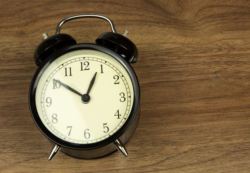 Old classic clock with the instructions lies on a wooden counter in vintage style. flat, horizontal view.
