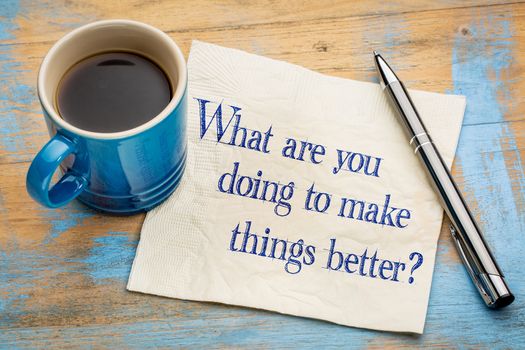 What are you doing to make things better? Handwriting  on a napkin with a cup of espresso coffee