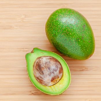 Fresh avocado on wooden background. Organic avocado healthy food concept. Avocado on Bamboo cutting board.The avocado is popular in vegetarian cuisine and weight control.