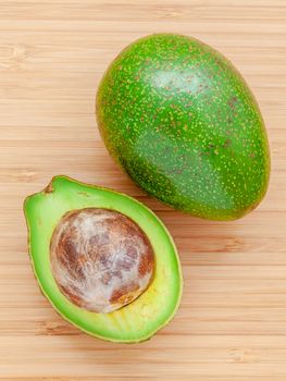 Fresh avocado on wooden background. Organic avocado healthy food concept. Avocado on Bamboo cutting board.The avocado is popular in vegetarian cuisine and weight control.