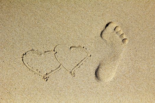 Heart and Prints of legs on sand