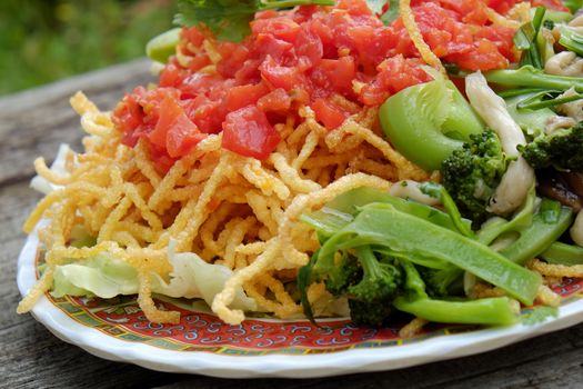 Vietnamese food, vegetarian eating from noodle with vegetable, meal for diet, rich fiber, colorful on plate with tomato, cabbage, mushroom, cauliflower
