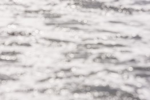 Background - blurred sea surface water with the reflection of sunlight