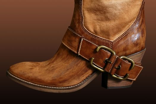 Female boot of the cowboy on a dark background