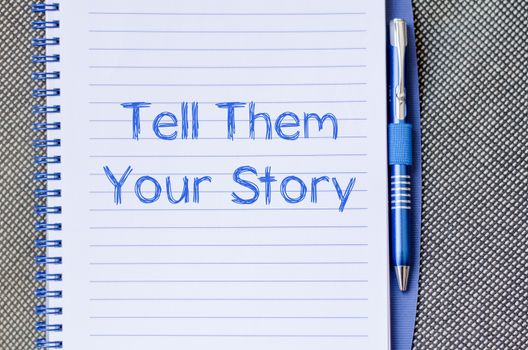 Tell them your story text concept write on notebook