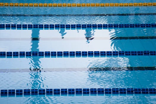 swimming pool detail with blue water and plastic lanes