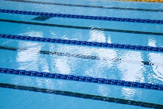 swimming pool detail with blue water and plastic lanes