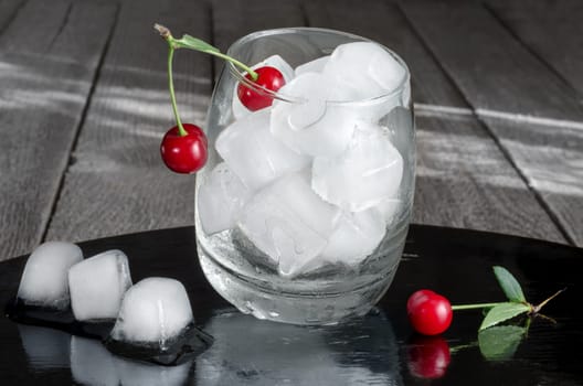 Ice cubes in a glass and cherries