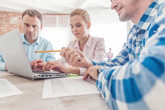 Diverse people working with financial reports and laptop