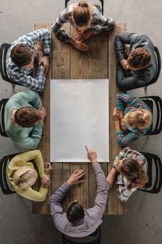 Hipster business teamwork brainstorming planning meeting concept, people sitting around the table with white paper