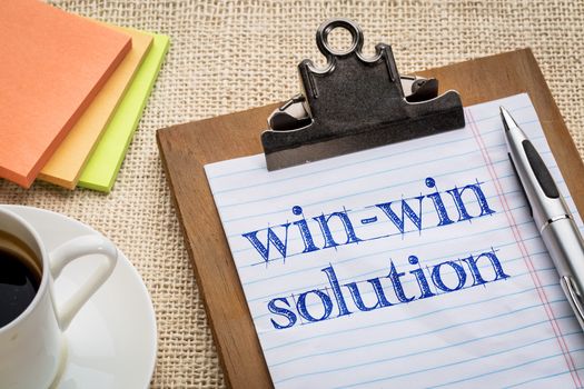 win-win solution concept - handwriting on a clipboard with a cup of coffee