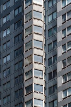 The windows of a highrise building creating a pattern of shapes and shades