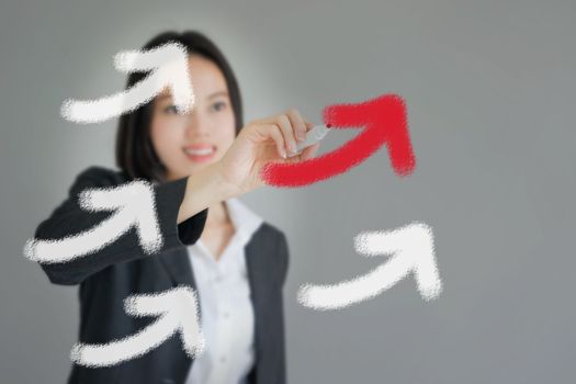 Young beautiful businesswoman drawing rising arrows