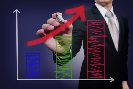 Businessman drawing a rising arrow over a bar graph