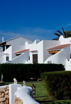 Traditional Country Holiday Houses in Sunny Day on Blue Sky background Outdoors. Balearic Islands, Menorca