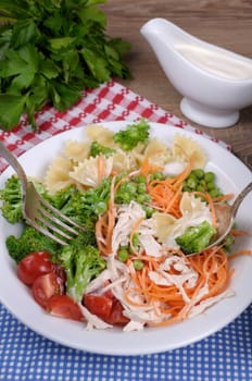  Salad of broccoli, peas, carrots, pasta, cherry tomatoes, slices of chicken in milk sauce