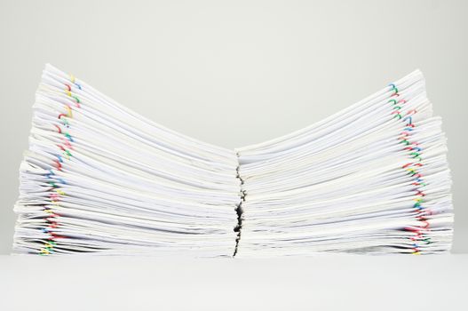 Dual pile overload document of report and receipt with colorful paperclip place on white background.