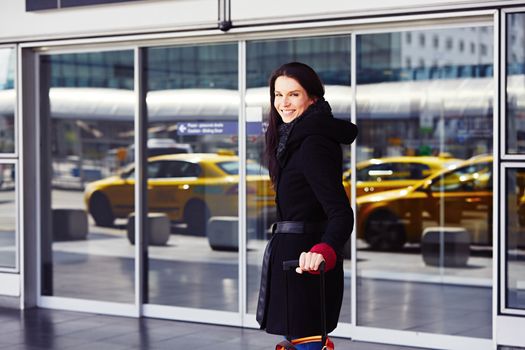 Successful woman in front of the terminal at the airport.