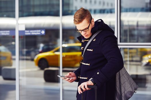 Young man is waiting for taxi at the airport.