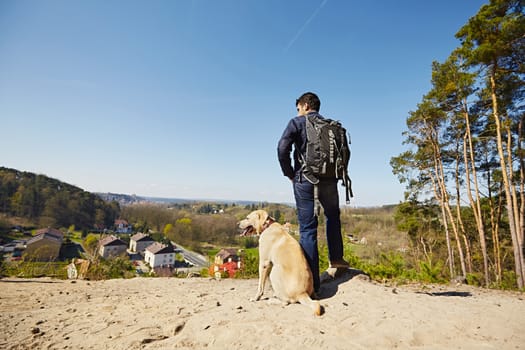 Young traveler with his dog on the hill