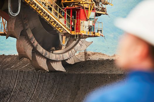 Coal mining in an open pit - Worker is looking on the huge excavator - industry in Czech Republic