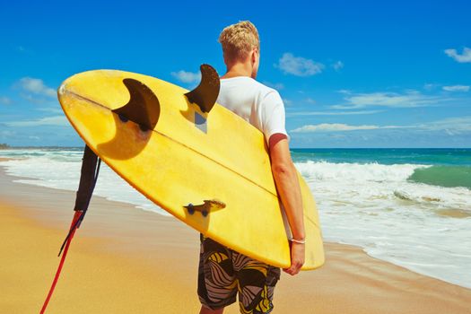 Man with surfboard on the beach at sunset.  