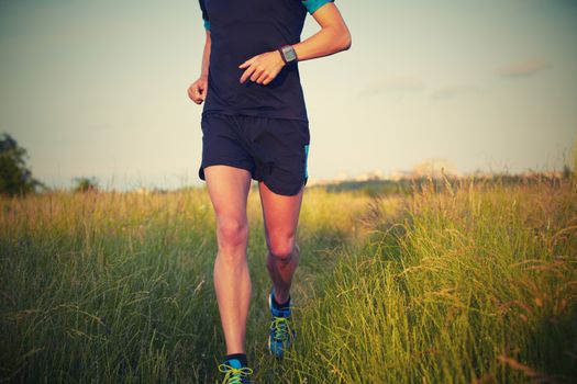 Young man is running on summer meadow - lovely sunset light