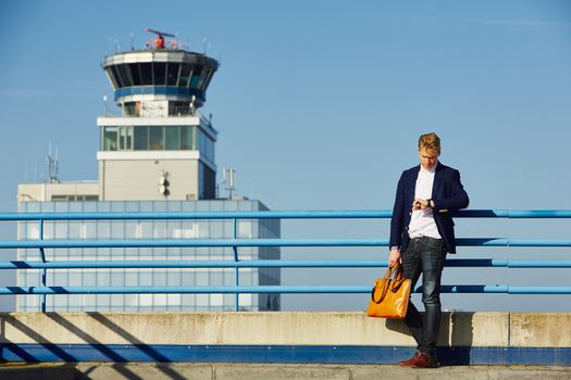 Handsome businessman is waiting at the airport 