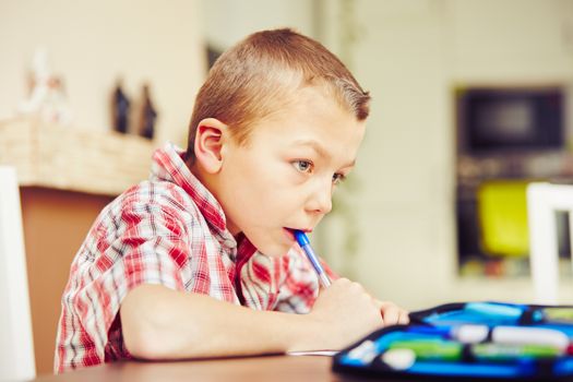 Little boy is doing his homework for elementary school.