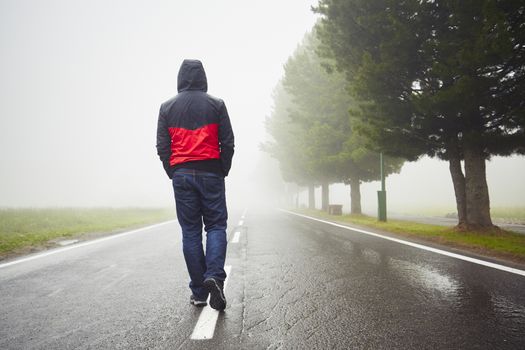 Lonely man is walking in mysterious fog