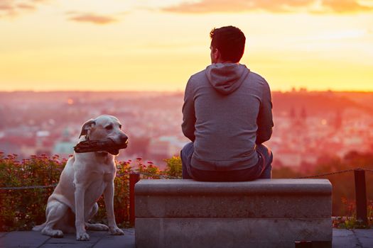 Young man with his dog at the sunrise.