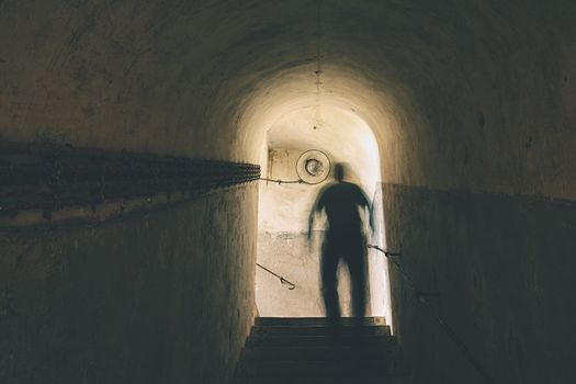 Man is walking through dark underground