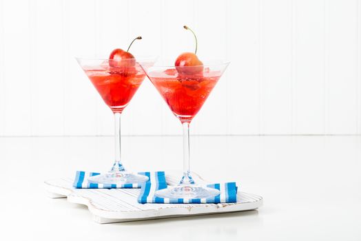 Fruity summer cocktail topped with a fresh whole cherry.