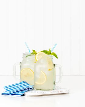 Two jars filled with ice cold homemade lemonade.