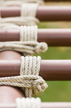 Close up of rope tied knot around metal pipe