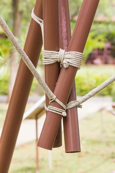 Close up of rope tied knot around metal pipe