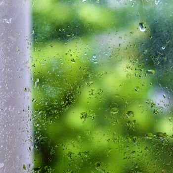 Rain drop on old window in rainy day, glass with green background as seperation, nice background for love