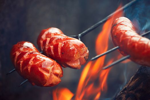 Sausages over the bondfire in nature - selective focus