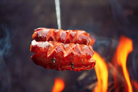 Sausages over the bondfire in nature - selective focus