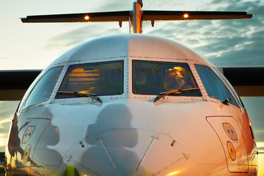 Preparation before take off - Cockpit of the airplane and shadow of the ground crew