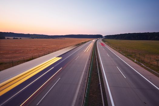 Traffic on the highway at the sunrise