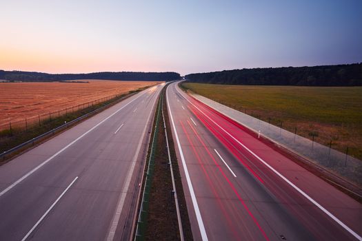 Traffic on the highway at the sunrise