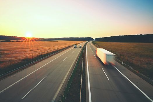 Traffic on the highway at the sunrise