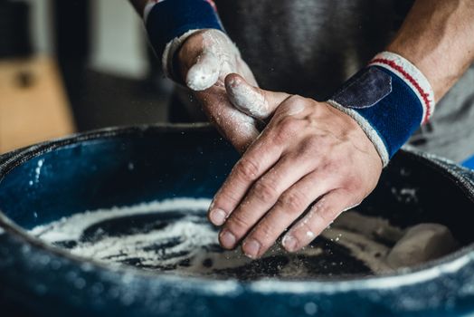 Chalking hands to prepare for weightlifting.