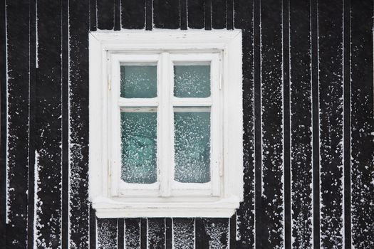 Single window of the wooden house in winter