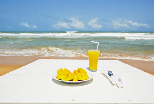 Fresh mango fruit and juice on the beach