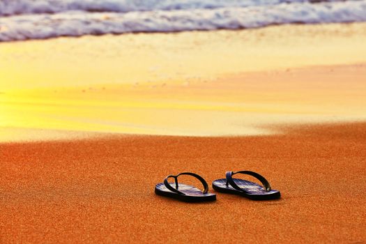 Flip flops on the beach at sunset