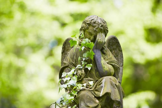 Sad angel statue on old cemetery 