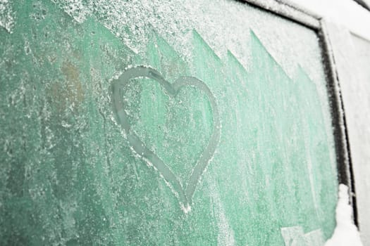 Heart symbol on frozen window of the car